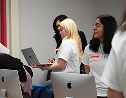 Image of a student showing her work to an Indutry Night attendee